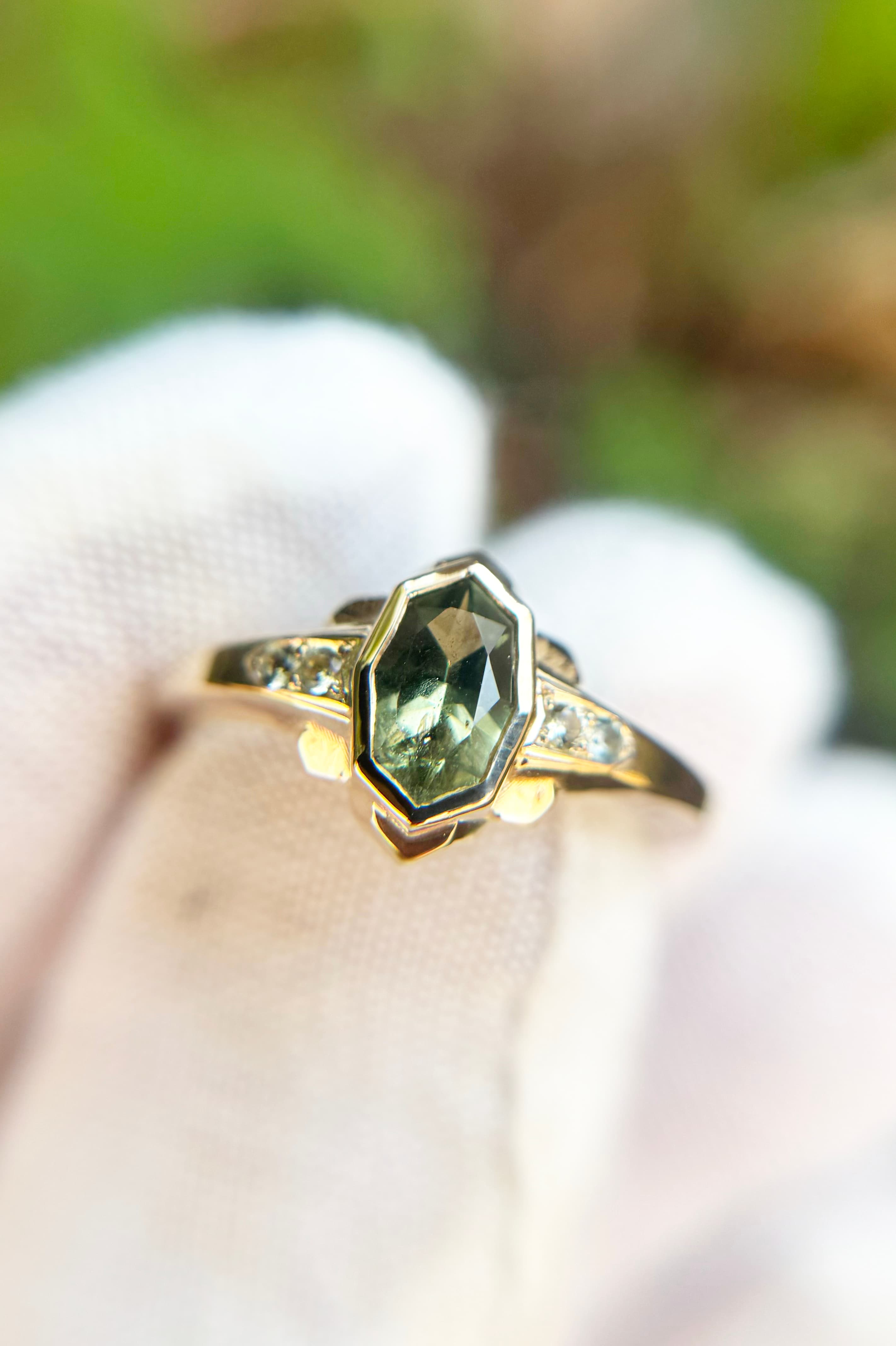 Gold ring with bezel-set green sapphire and diamond side stones